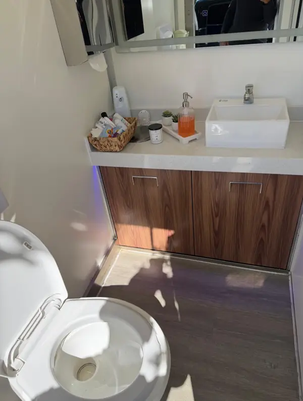 Wood vanity and vessel sink inside a luxury restroom trailer